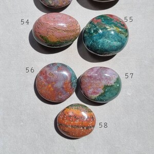 Pu&ograve; includere: Sette pietre lisce e levigate con vari motivi di verde, rosa, arancio e marrone. Le pietre sono numerate da 52 a 58.