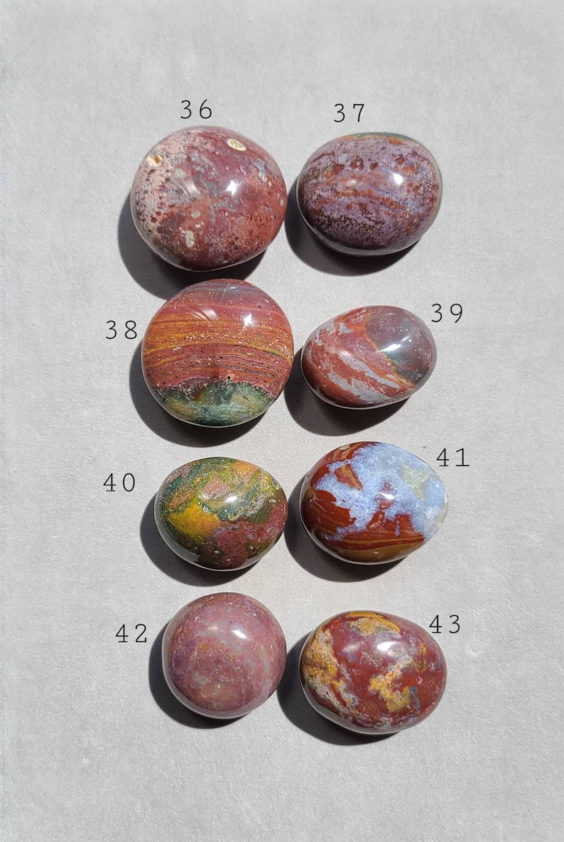 Pu&ograve; includere: Sette pietre di diaspro lisce e levigate, di colore rosso, marrone e verde, con segni bianchi e dorati. Le pietre sono numerate da 36 a 43.