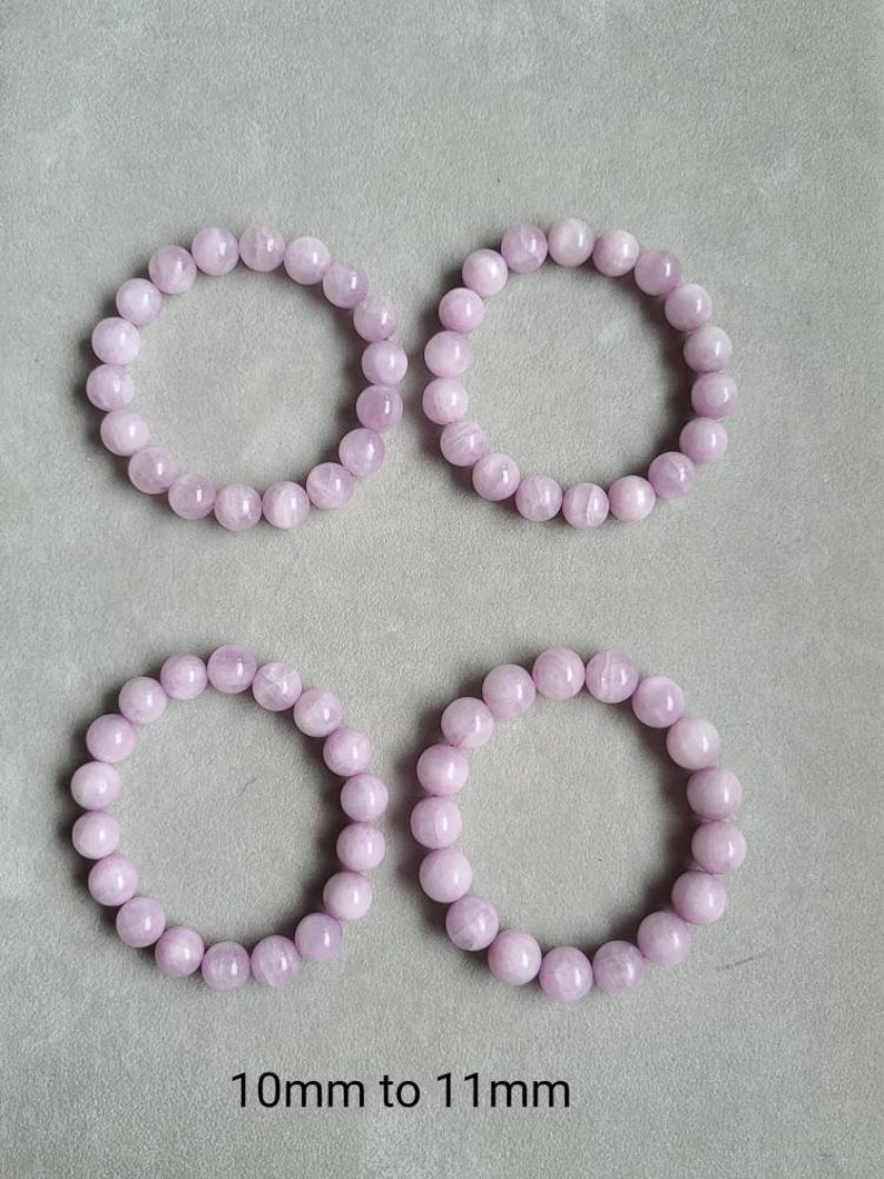Peut inclure: Quatre bracelets en perles de pierres pr&eacute;cieuses de couleur lilas clair. Les perles sont rondes et mesurent de 10 &agrave; 11 mm de diam&egrave;tre.