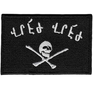 May include: Black rectangular patch featuring a white skull and crossbones design. White text is embroidered above the skull. This patch could be used as an accessory on clothing or bags.