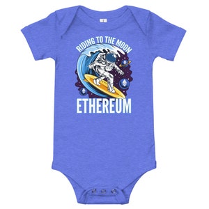 May include: A blue baby grow with a graphic of an astronaut riding a surfboard in space. The text "Riding to the Moon" is above the astronaut and "Ethereum" is below. The astronaut is holding a surfboard with the text "ETH" on it.