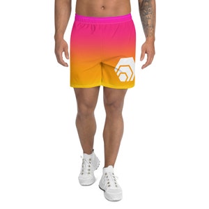 May include: A pair of athletic shorts with a gradient design in shades of pink and yellow. The shorts have a white geometric logo on the right leg.