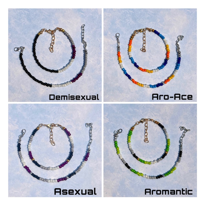 K&ouml;nnte beinhalten: Vier Armb&auml;nder mit Perlen und goldfarbenen Kettenakzenten. Jedes Armband hat ein anderes Farbschema und den Text: "Demisexual", "Aro-Ace", "Asexual" und "Aromantic". Die Armb&auml;nder befinden sich auf einem hellblauen Hintergrund.