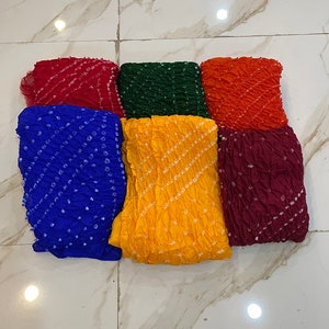 Peut inclure: Six carr&eacute;s de tissu color&eacute;s avec un motif tie-dye. Les carr&eacute;s sont dispos&eacute;s en deux rang&eacute;es de trois. Les couleurs sont rouge, vert, orange, bleu, jaune et marron.