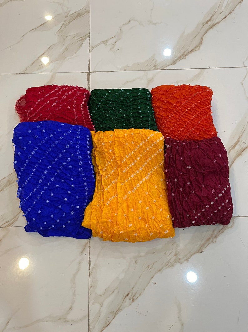 Peut inclure: Six carr&eacute;s de tissu color&eacute;s avec un motif tie-dye. Les carr&eacute;s sont dispos&eacute;s en deux rang&eacute;es de trois. Les couleurs sont rouge, vert, orange, bleu, jaune et marron.