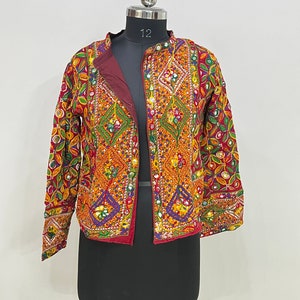 May include: A red, yellow, and green embroidered jacket with mirror embellishments. The jacket has a mandarin collar and long sleeves.