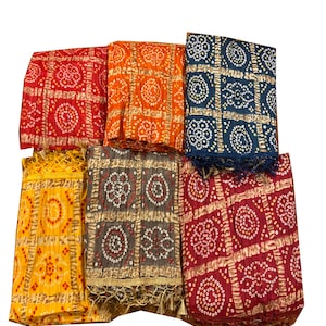 May include: Six colorful scarves with a white and gold geometric pattern and small white dots. The scarves have a fringe border.