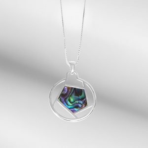 May include: A silver necklace with a round pendant featuring a geometric design and a colorful abalone shell inlay.