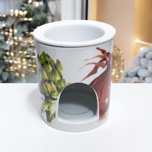 Könnte beinhalten: Weißer Keramik-Ölbrenner mit floralem Design mit Artischocken und einer roten Blume. Der Brenner hat eine runde Öffnung in der Mitte für ein Teelicht.
