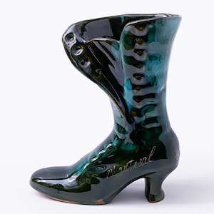 May include: A green ceramic boot-shaped vase with gold lettering that reads "Montreal".