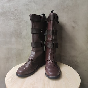 May include: A pair of brown leather boots with buckles and straps. The boots have a pointed toe and a low heel.