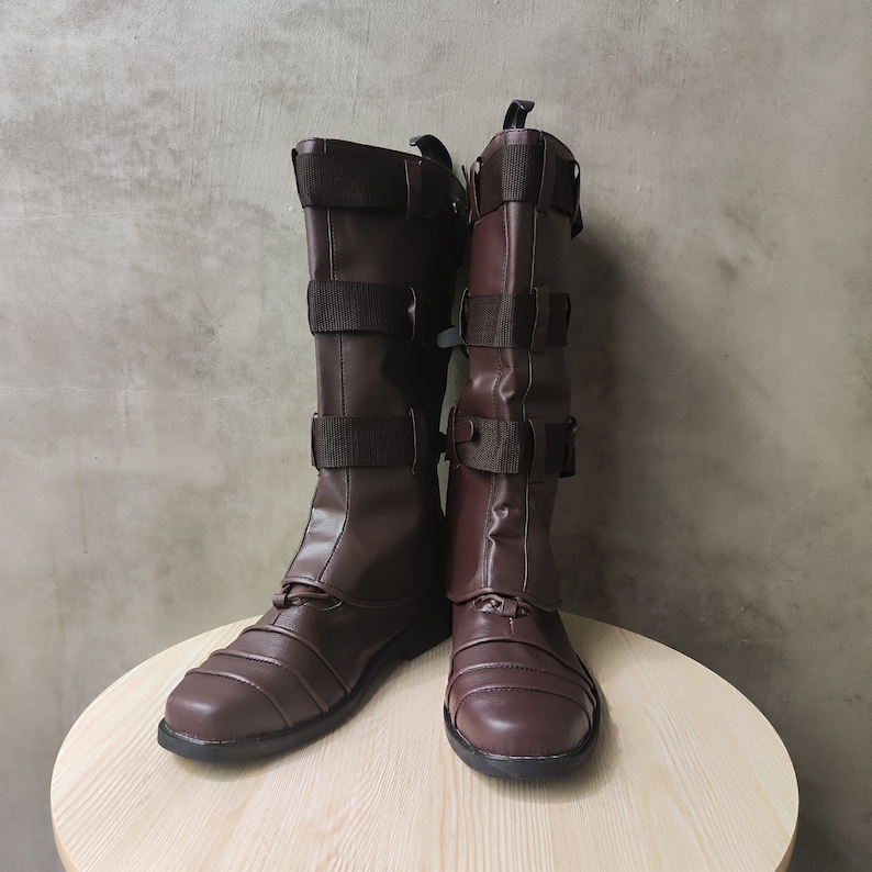 May include: A pair of brown leather boots with buckles and straps. The boots have a pointed toe and a low heel.
