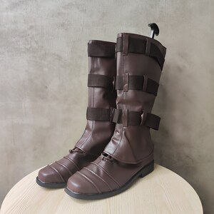 May include: A pair of brown leather boots with buckles and straps. The boots have a pointed toe and a chunky heel.