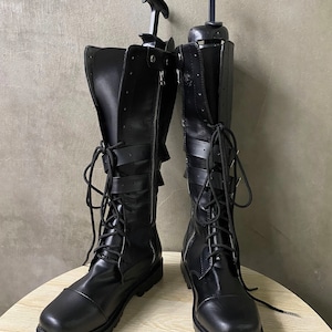May include: A pair of black leather boots with buckles and laces. The boots have a round toe and a chunky heel.