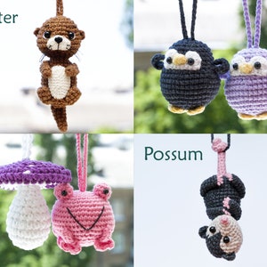 Puede incluir: Un conjunto de cinco peluches de animales de crochet, que incluyen una nutria, un ping&uuml;ino, un p&aacute;jaro morado, una rana y un opossum. Los peluches est&aacute;n colgados de cuerdas y son de diferentes colores.