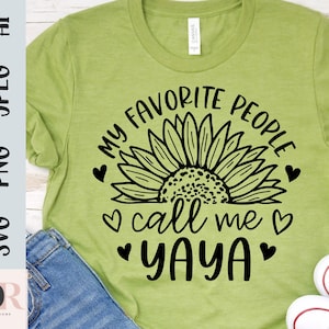 K&ouml;nnte beinhalten: Gr&uuml;nes T-Shirt mit einem schwarzen Sonnenblumen-Motiv und dem Text "Meine Lieblingsmenschen nennen mich Yaya".