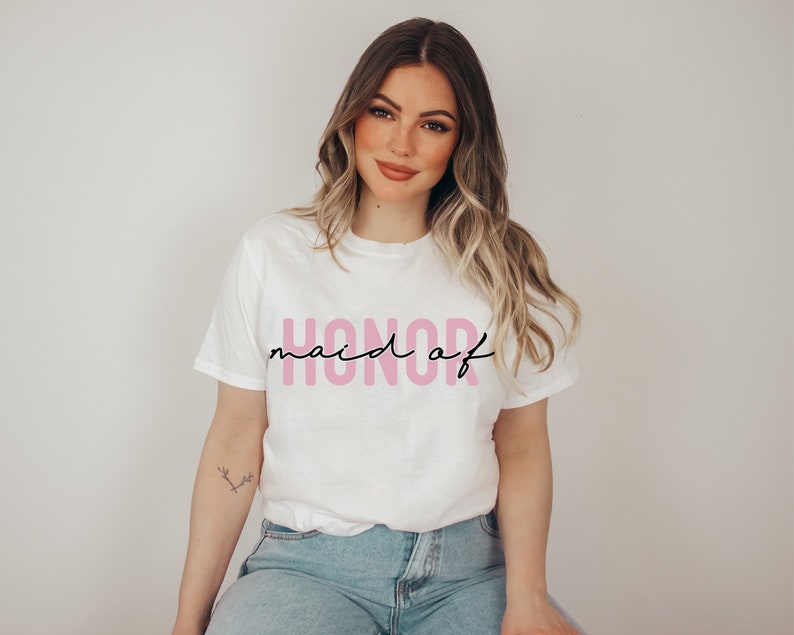 May include: White t-shirt with the text "maid of honor" in pink lettering.