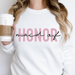 May include: White sweatshirt with the text "HONOR maid of" in pink letters with black script.