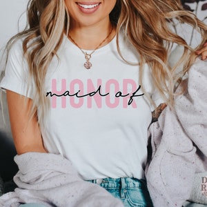 May include: A white t-shirt with the text "honor maid of" in black lettering with the word "maid" in pink.