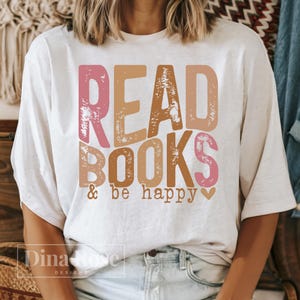 May include: White t-shirt with a pink, brown, and orange graphic that says "Read Books & be happy" with a small heart.