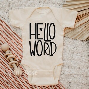 May include: A white baby onesie with black text that reads "HELLO WORLD" with a small heart between the words.