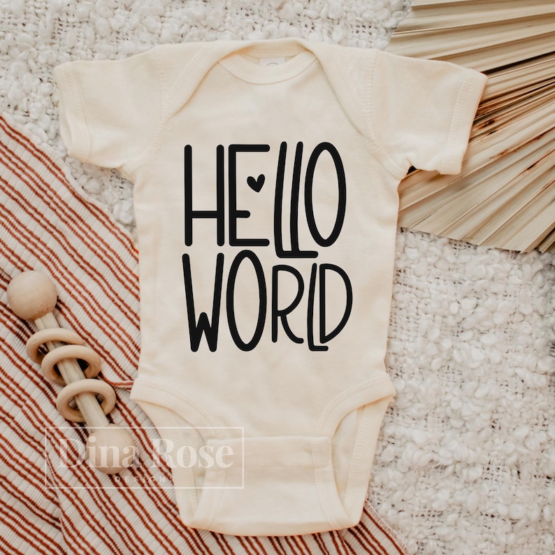 May include: A white baby onesie with black text that reads "HELLO WORLD" with a small heart between the words.