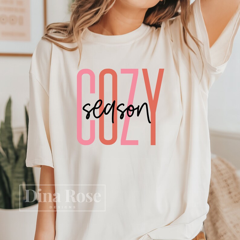 May include: A white t-shirt with the text "COZY season" in pink and red lettering.
