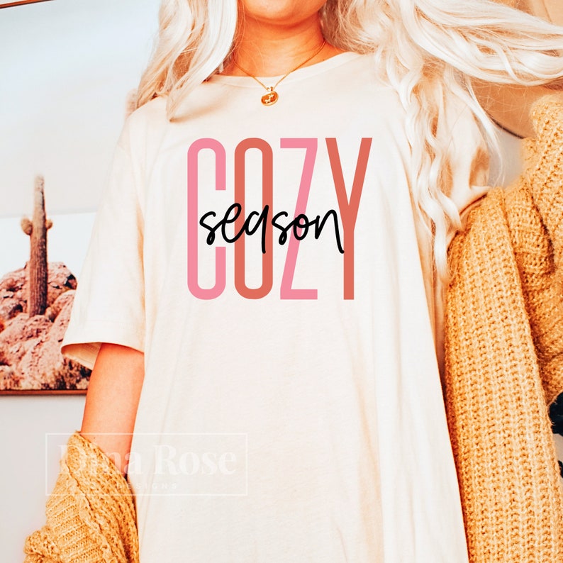 May include: A white t-shirt with the text "COZY season" in pink and brown lettering.
