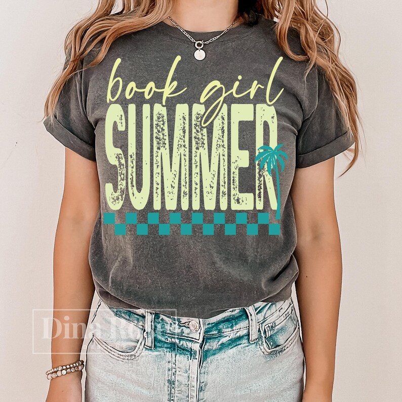 May include: A gray t-shirt with the words "book girl SUMMER" in yellow and green, with a palm tree graphic. The shirt has a checkered pattern in teal and green. The shirt is worn by a person.
