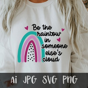 May include: White sweatshirt with a rainbow graphic and the text "Be the rainbow in someone else's cloud".