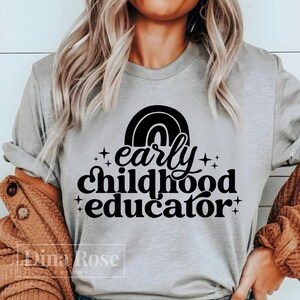 May include: A gray t-shirt with a black rainbow and the text "early childhood educator" in a retro font.
