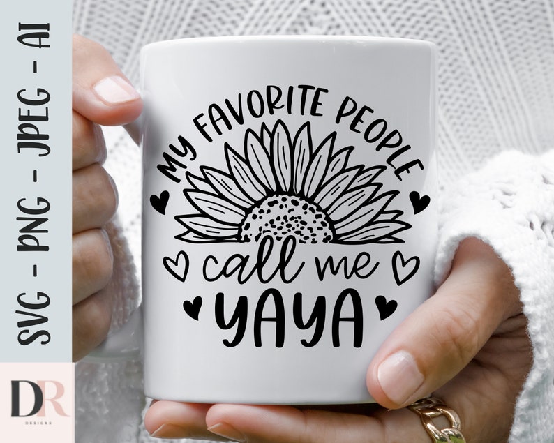 K&ouml;nnte beinhalten: Eine wei&szlig;e Keramiktasse mit einem schwarzen Sonnenblumenmuster und dem Text "Meine Lieblingsmenschen nennen mich Yaya".