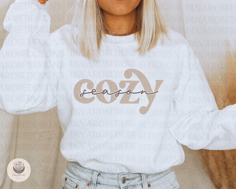 May include: White sweatshirt with a brown graphic that says "cozy season" in a retro font.
