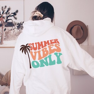 May include: White hoodie with a palm tree and the text "SUMMER VIBES ONLY" in colorful retro font.