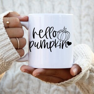 May include: White ceramic mug with a black design that says "hello pumpkin" with a small pumpkin and heart graphic.