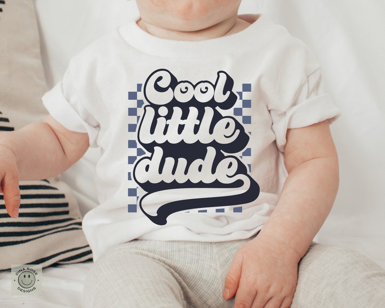 May include: A white baby onesie with a blue checkered background and the text "Cool little dude" in a retro font.