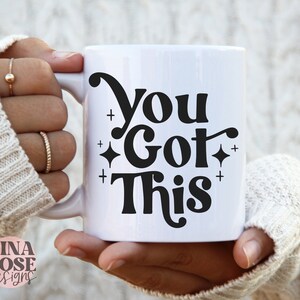 Puede incluir: Taza de cer&aacute;mica blanca con un dise&ntilde;o negro que dice "You Got This" con peque&ntilde;as estrellas a cada lado del texto.