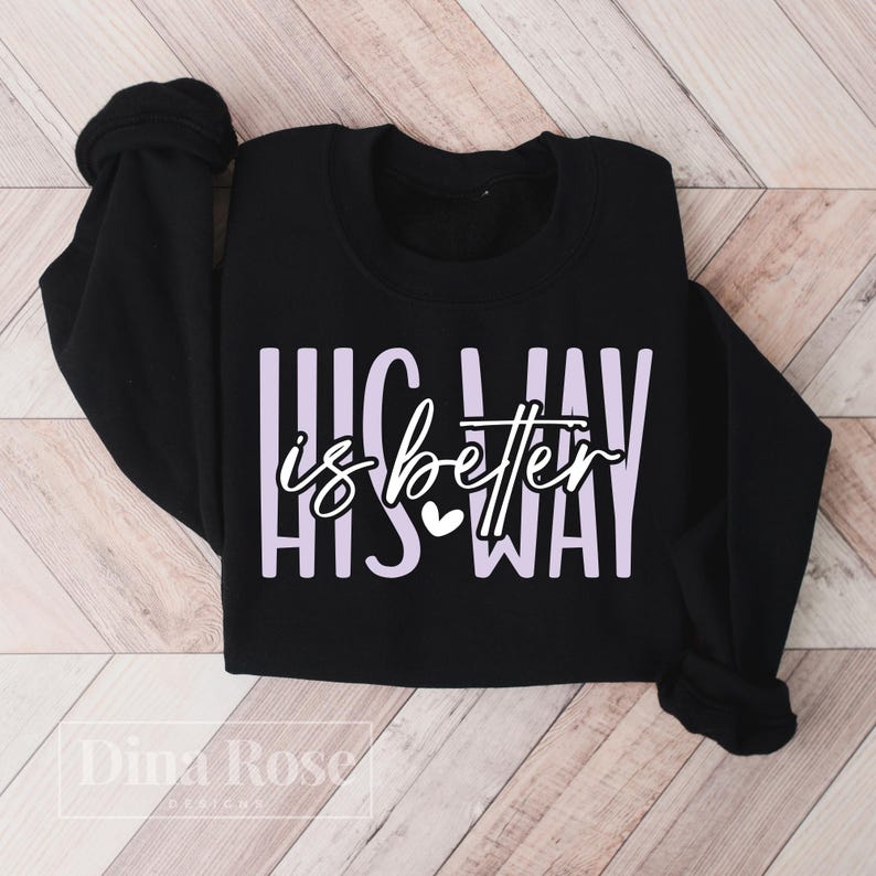 May include: Black sweatshirt with the text "HIS WAY is better HIS WAY" in white and lavender. A small white heart is between the words "is" and "better". The sweatshirt has long sleeves and a crew neck.