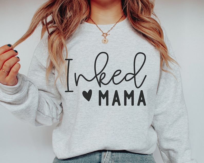 May include: A gray sweatshirt with the text "Inked Mama" in black lettering with a small heart symbol.