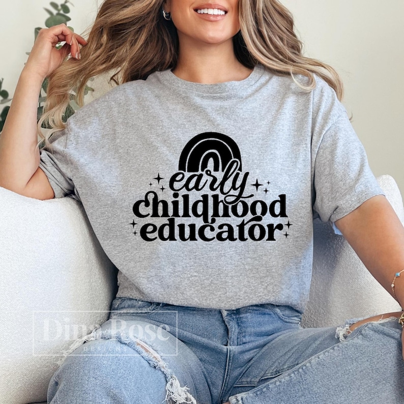 May include: A gray t-shirt with a black graphic that says "early childhood educator" with a rainbow above the text.
