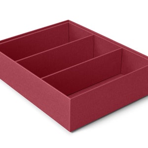 Puede incluir: Una caja de almacenamiento rectangular de color burdeos con tres compartimentos internos. La caja tiene una superficie texturizada y está diseñada para organizar artículos. Los divisores crean secciones separadas.