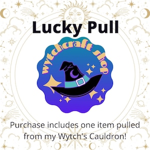 May include: A blue and purple circle with a witch's hat and stars. The text "Witchcraft Shop" is written around the hat. The text "Lucky Pull" is above the circle. The text "Purchase includes one item pulled from my Wytch's Cauldron!" is below the circle.