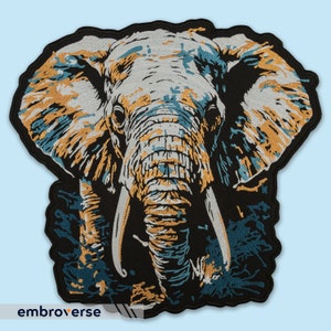 Könnte beinhalten: Gestickter Patch mit dem Kopf eines Elefanten in blau-goldener Farbgebung. Der Rüssel des Elefanten ist lang und der Patch befindet sich auf einem schwarzen Hintergrund.