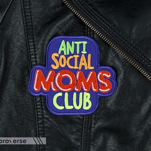 May include: A blue, orange, green, and red embroidered patch with the text "Anti Social Moms Club" on a black leather jacket.