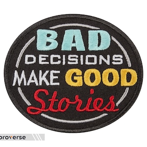 Może przedstawiać: Czarna naszywka haftowana z białymi, żółtymi, czerwonymi i niebieskimi literami. Tekst brzmi "Bad Decisions Make Good Stories".