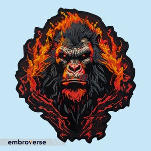 Puede incluir: Parche bordado de la cara de un gorila con llamas detrás. El gorila tiene una expresión seria y está rodeado de llamas naranjas y amarillas.