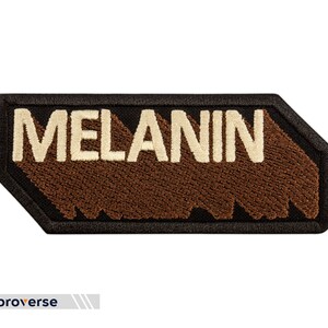 Peut inclure: Un patch brod&eacute; marron et noir avec le mot "MELANIN" en lettres blanches.