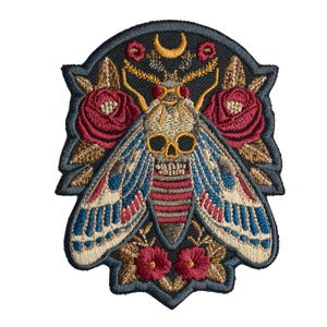 May include: An embroidered patch featuring a central moth with a skull-shaped thorax, surrounded by red roses and brown leaves on a black background. The moth has cream, blue, and red wings, with a small yellow crescent moon above its head.