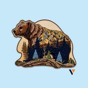Può includere: Una toppa ricamata a forma di orso con un design a doppia esposizione. La testa dell'orso è marrone, mentre il corpo raffigura un paesaggio di montagne gialle, pini blu scuro e un primo piano marrone chiaro con piccole piante verdi.