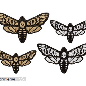 May include: Four embroidered iron-on patches of a death's-head hawk moth with a skull design. Two patches are black and white, and two patches are black with a gold-colored moth.